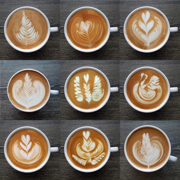 Collection of top view of  latte art coffee mugs on timber background.